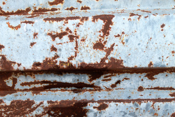 Multicolored background: rusty metal surface with blue paint flaking and cracking texture