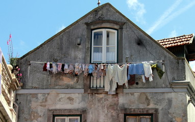 Washed clothes drying in the sun in old Portuguese town.