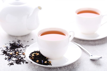Obraz na płótnie Canvas Cups of tea with dry leafs and teapot