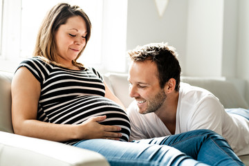 A pregnancy and people concept happy man pregnant woman at home