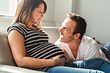 A pregnancy and people concept happy man pregnant woman at home