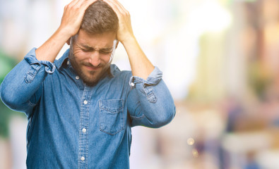 Young handsome man over isolated background suffering from headache desperate and stressed because pain and migraine. Hands on head.