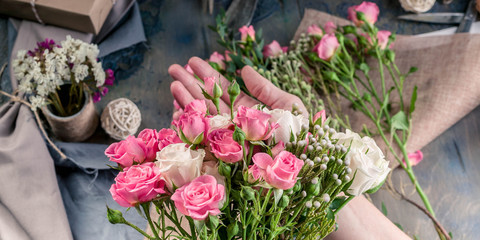 Web banner. Small business concept. Work process of florist. Female hands making wedding bouquet on a dark table