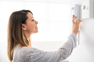 A woman set the thermostat at house