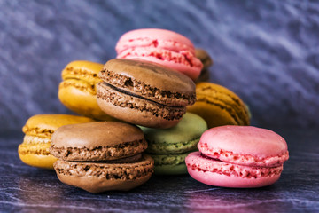 Concept sweets, enjoyment of the senses. Close up of French macaroons on a colorful background. Shallow depth of focus.