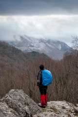 Hiker in the mountains with blue backpack