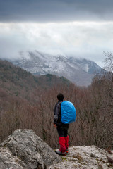Fototapeta premium Hiker in the mountains with blue backpack
