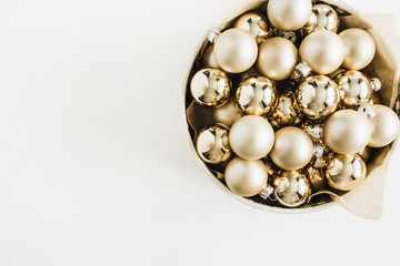 Box with golden Christmas decoration balls on white background. Flat lay, top view blog hero header.