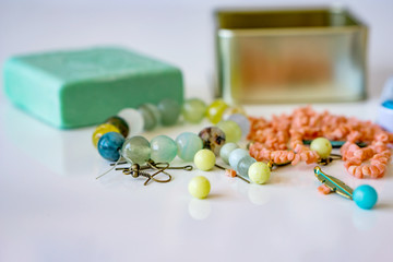 Close-up of scattered beads of natural stonesand  gift box with natural olive blured soap, on a white background. Gift set. Shallow depth of focus, copy space.