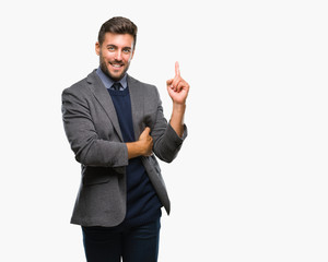 Young handsome business man over isolated background with a big smile on face, pointing with hand and finger to the side looking at the camera.
