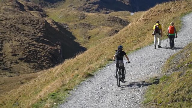 traveller biking and trekking on the mountain with backpack and beautiful blue sky at First Grindelwald,Swizerland.Happy Vacation holiday outdoor scene landscape.Travel journey freedom concept.