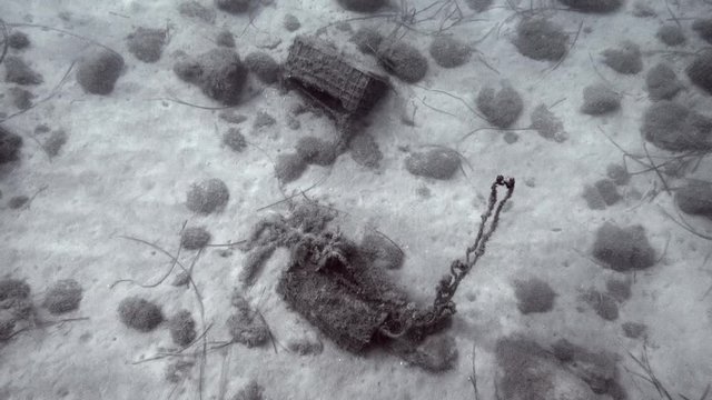 A boat's chain line and trush under sea in Greece