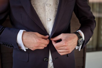 the man buttoning hands a jacket