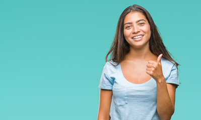 Young beautiful arab woman over isolated background doing happy thumbs up gesture with hand. Approving expression looking at the camera with showing success.
