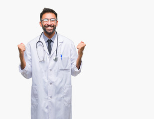 Adult hispanic doctor man over isolated background celebrating surprised and amazed for success with arms raised and open eyes. Winner concept.