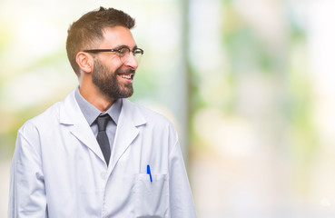 Adult hispanic scientist or doctor man wearing white coat over isolated background looking away to...