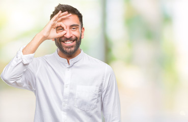 Naklejka premium Adult hispanic man over isolated background doing ok gesture with hand smiling, eye looking through fingers with happy face.