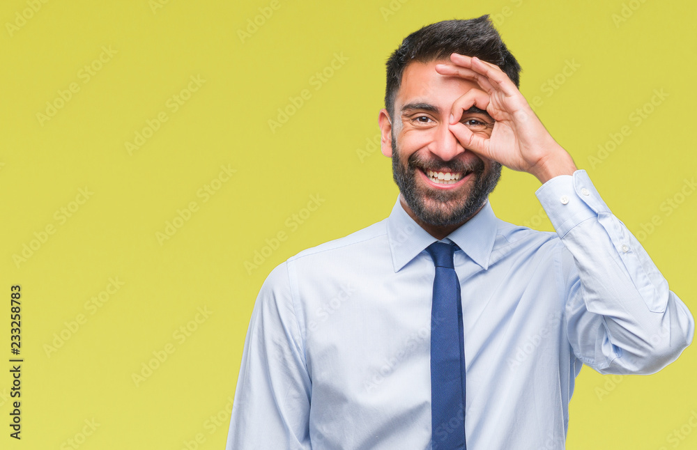 Wall mural adult hispanic business man over isolated background doing ok gesture with hand smiling, eye looking