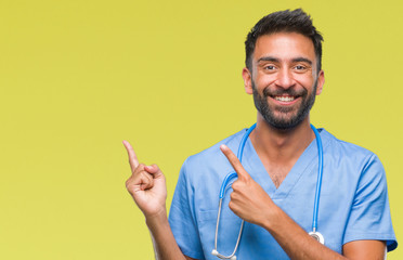Adult hispanic doctor or surgeon man over isolated background smiling and looking at the camera...
