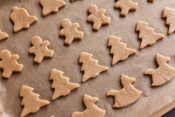 Fototapeta na wymiar Homemade Christmas gingerbread. Raw dough. Bells, little men, horses, Christmas trees. Winter background