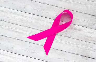 Concept of female health, pink ribbon on a background of wood, breast cancer and the fight against...