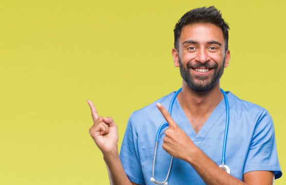 Adult Hispanic Doctor Or Surgeon Man Over Isolated Background Smiling And Looking At The Camera Pointing With Two Hands And Fingers To The Side.