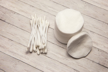 Clean cotton pads and chopsticks on a wooden background, top view