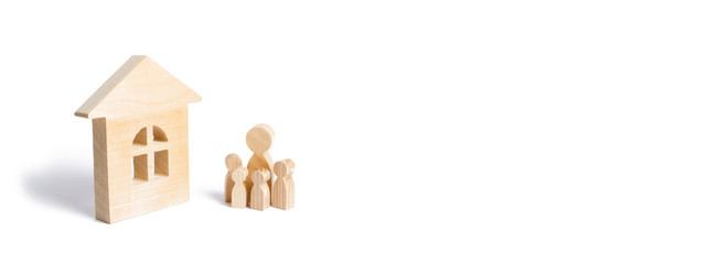 A young family with children is standing near a wooden house. The concept of a strong family, the continuation of the family. Loans for the purchase of affordable housing. A house for a family. banner