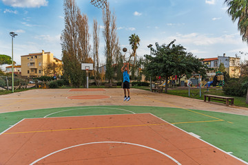 Fototapeta premium Basketball player working out in a outdoor court
