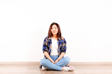 Fototapeta na wymiar Portrait of beautiful asian young woman with brunette hair and bob hairstyle, fashionable hipster outfit alone in bright lighted room. Background, copy space for text, close up.