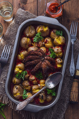 Grilled octopus with baked potatoes, tomato sauce and wine