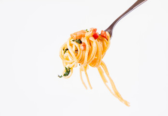 Spaghetti Carbonara with some parsley on a fork on a white background