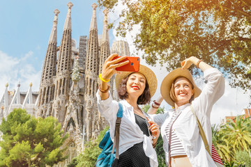 BARCELONA, SPAIN - 11 JULY 2018: Young girls friends making selfie photo on her smartphone in front...