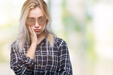 Fototapeta na wymiar Young blonde woman wearing sunglasses over isolated background thinking looking tired and bored with depression problems with crossed arms.