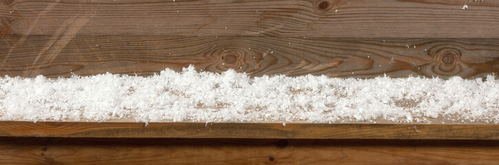 Christmas or winter background. Piled snow on a wooden bench, banner