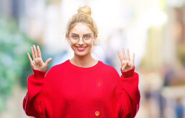 Young beautiful blonde woman wearing red sweater and glasses over isolated background showing and...