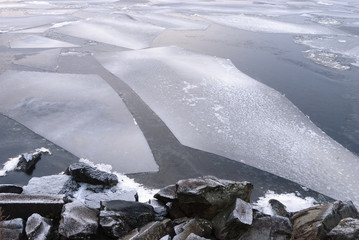 Freezing lake ice and granite rocks