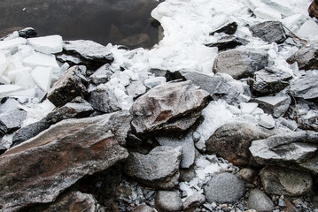 Ice and granite rocks on the beach