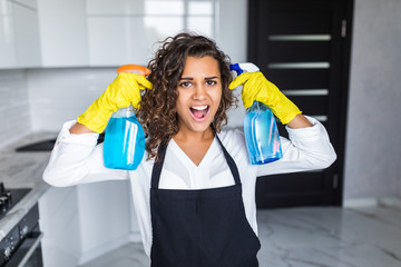 Young happy latin woman is having fun while doing cleaning at home.