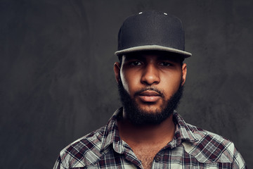 African-American guy wearing a checkered shirt and cap