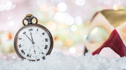 Carnival party. Minutes to midnight on an old watch, colorful mask, bokeh festive background