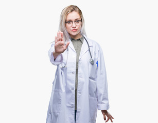 Young blonde doctor woman over isolated background doing stop sing with palm of the hand. Warning expression with negative and serious gesture on the face.