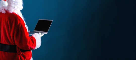 Santa using a laptop on a dark blue background