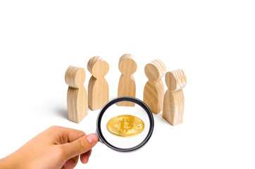 Wooden figurines of people are standing around a bitcoin coin on a white background. cryptocurrency...