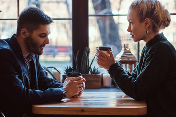 Romantic couple in the cafe is drinking coffee and talking. 