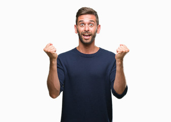 Fototapeta premium Young handsome man wearing winter sweater over isolated background celebrating surprised and amazed for success with arms raised and open eyes. Winner concept.
