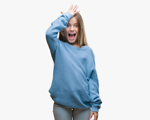 Young beautiful girl wearing winter sweater over isolated background surprised with hand on head...