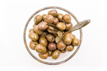 Bowl with olives and olive branch on a white background seen from above