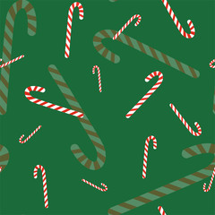 Christmas seamless pattern with striped candies on green background. Vector.