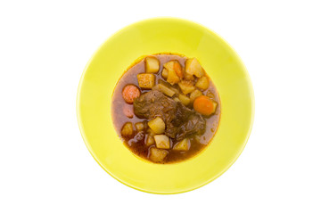 Stewed meat and vegetables on a white background seen from above